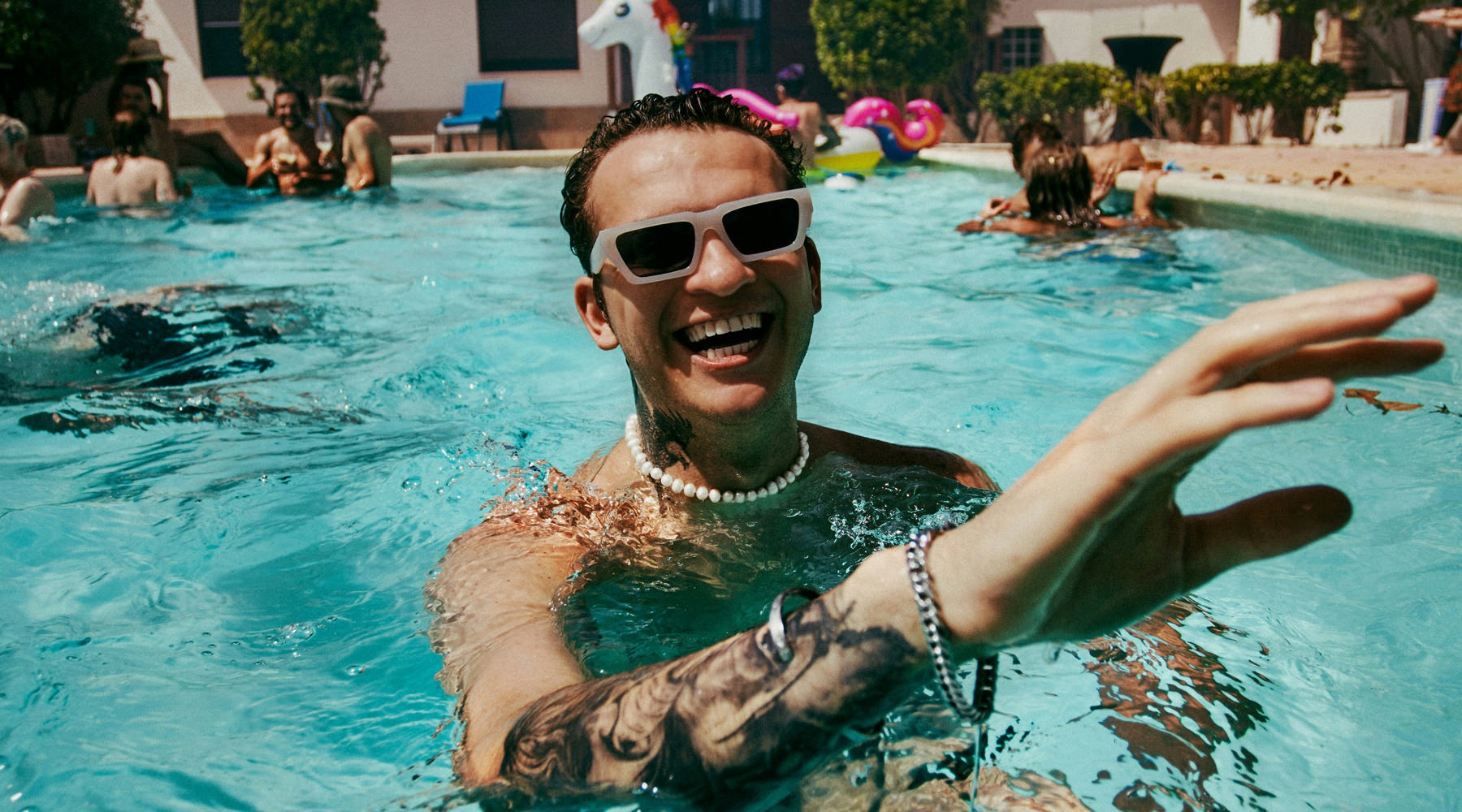 man in pool with tatoots